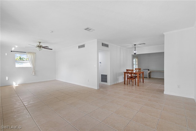 tiled spare room with ceiling fan and crown molding