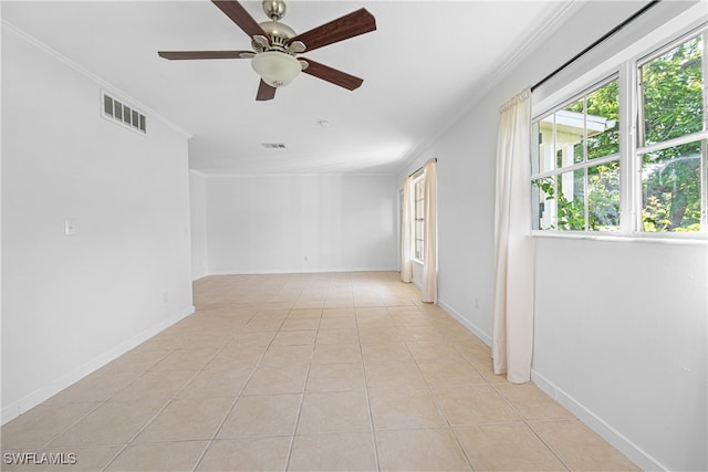 empty room with ceiling fan, light tile patterned floors, and ornamental molding