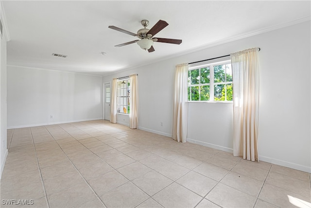 tiled spare room with ornamental molding and ceiling fan