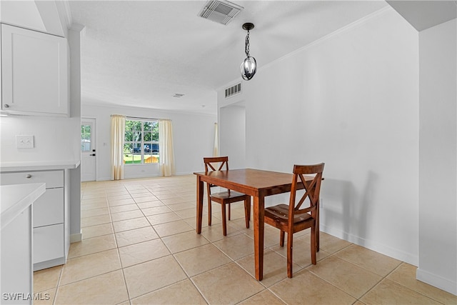 dining room featuring ornamental molding and light tile patterned flooring