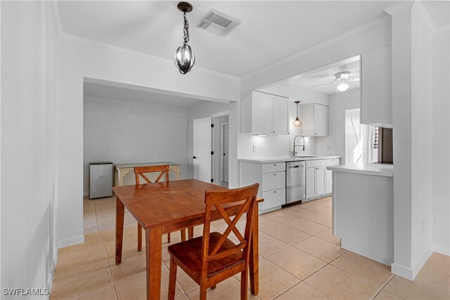 dining space featuring light tile patterned flooring, ceiling fan, sink, and ornamental molding