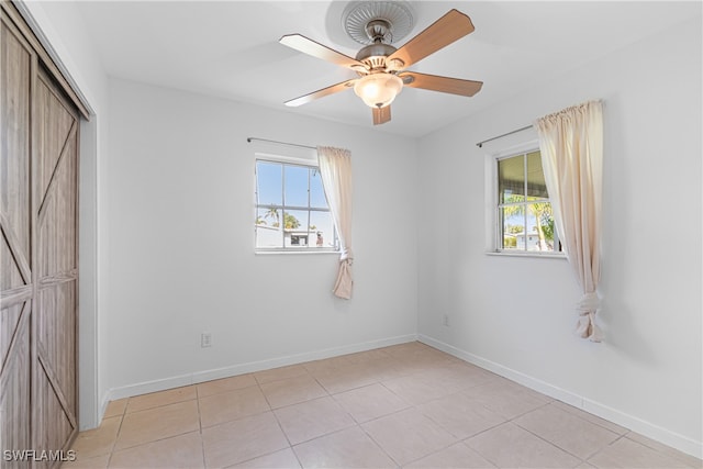 unfurnished bedroom featuring light tile patterned flooring, ceiling fan, and a closet