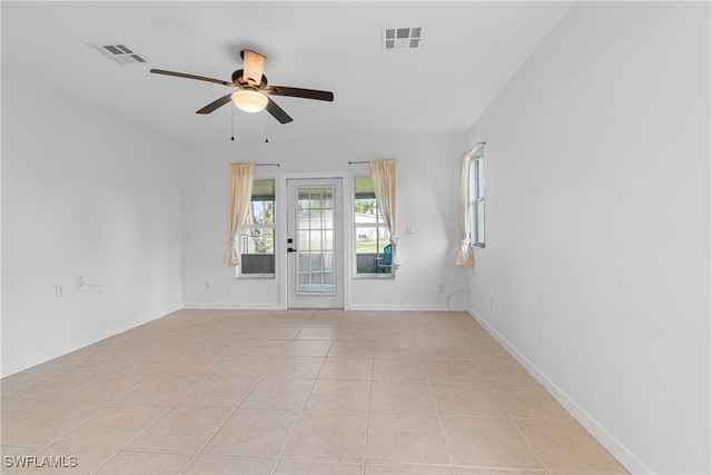 empty room with ceiling fan and light tile patterned floors