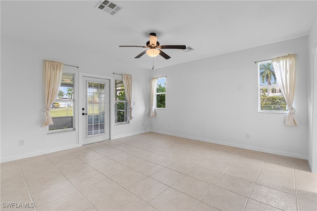 spare room with ceiling fan and light tile patterned floors