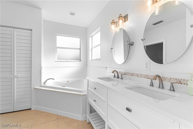 bathroom featuring a bathing tub, vanity, tasteful backsplash, and tile patterned floors