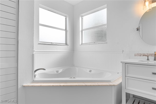 bathroom with vanity and a bath