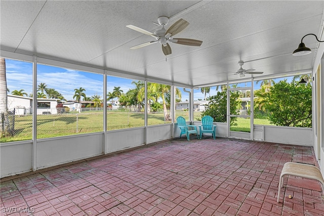 unfurnished sunroom featuring ceiling fan