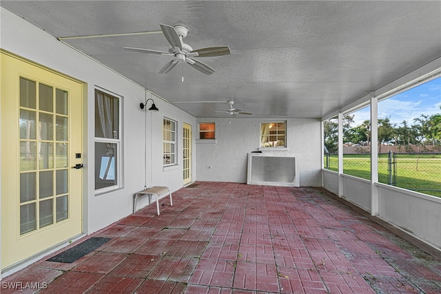 unfurnished sunroom with ceiling fan