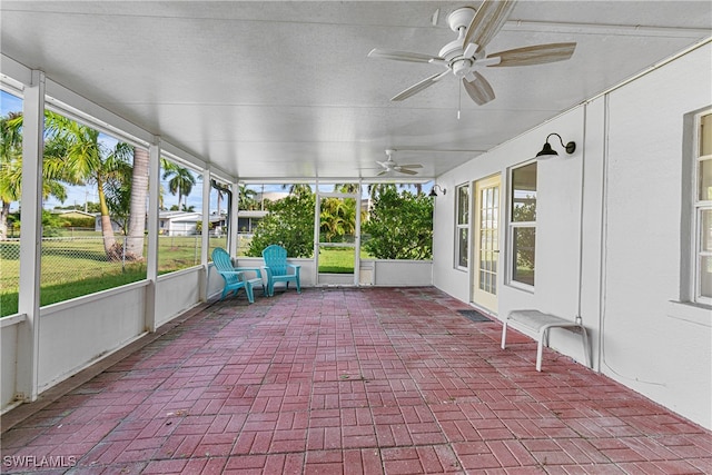 unfurnished sunroom featuring plenty of natural light and ceiling fan