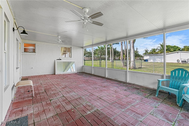 unfurnished sunroom with ceiling fan