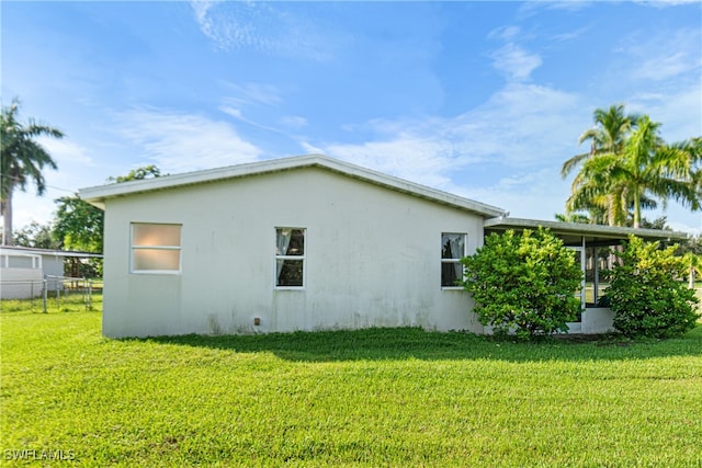 view of home's exterior with a lawn and a sunroom