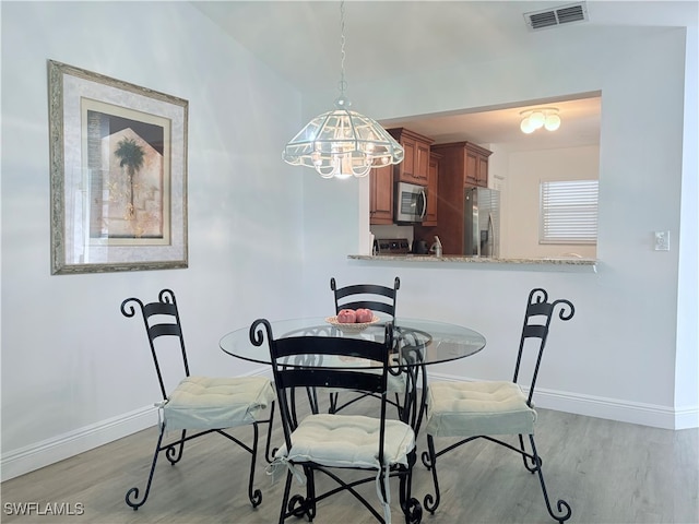 dining area featuring light wood-type flooring and a chandelier