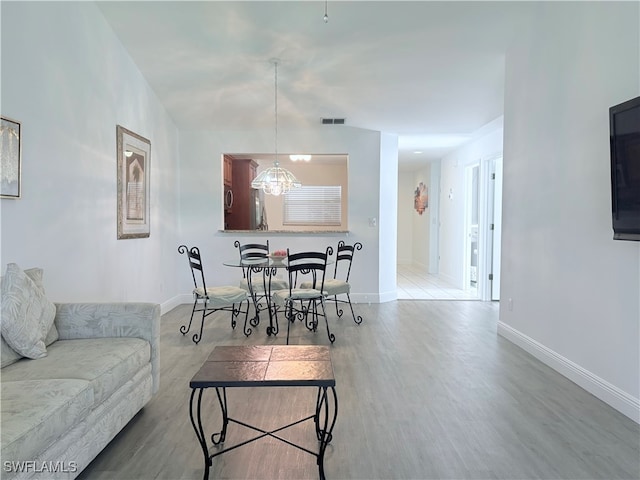 living room with wood-type flooring and a notable chandelier