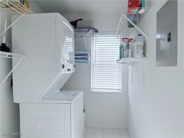 laundry area with stacked washing maching and dryer, electric panel, and light tile patterned flooring