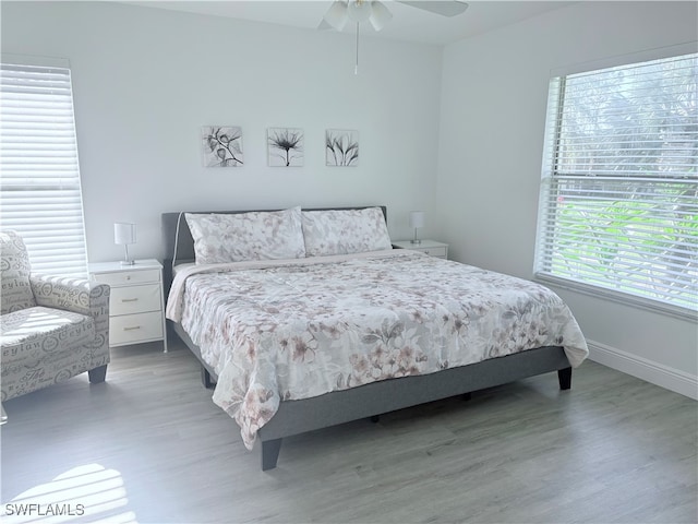 bedroom featuring wood-type flooring, multiple windows, and ceiling fan