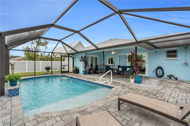 view of swimming pool featuring ceiling fan, a lanai, and a patio area