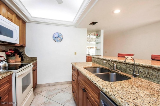 kitchen with crown molding, light stone counters, white appliances, and sink