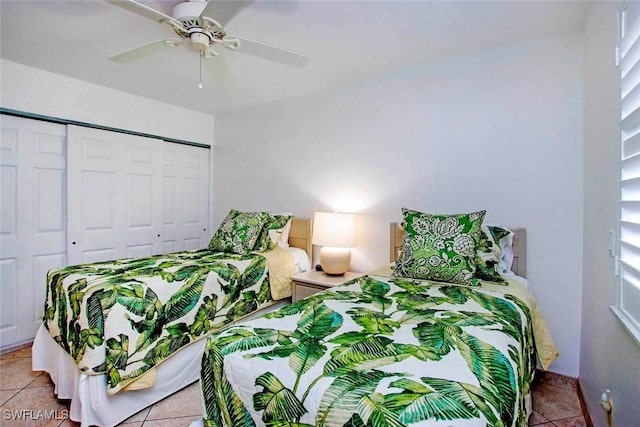 tiled bedroom featuring ceiling fan and a closet