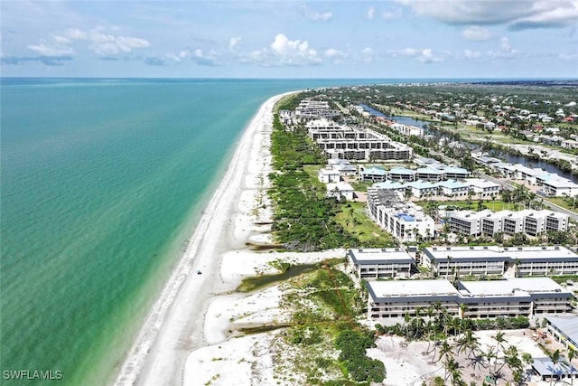 birds eye view of property featuring a water view and a beach view