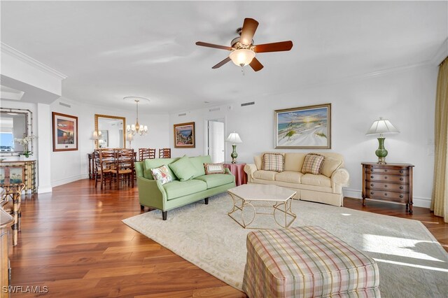 living room featuring ceiling fan with notable chandelier, dark hardwood / wood-style floors, and crown molding