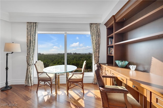 dining space featuring hardwood / wood-style flooring and crown molding