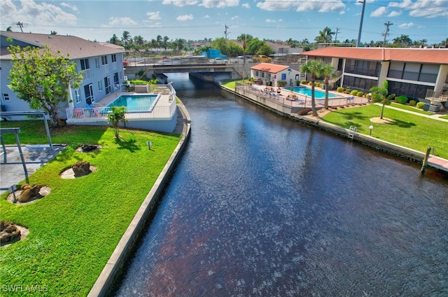 view of pool featuring a patio and a water view