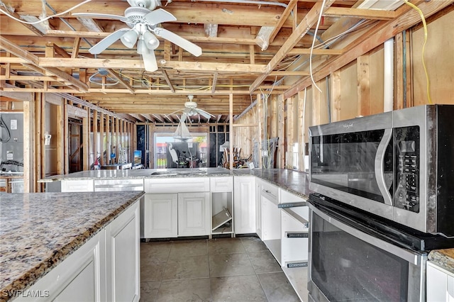 kitchen featuring stainless steel appliances, stone countertops, ceiling fan, and white cabinets