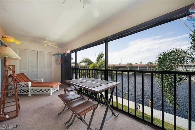 interior space with ceiling fan and a water view