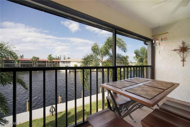 balcony featuring a water view and ceiling fan