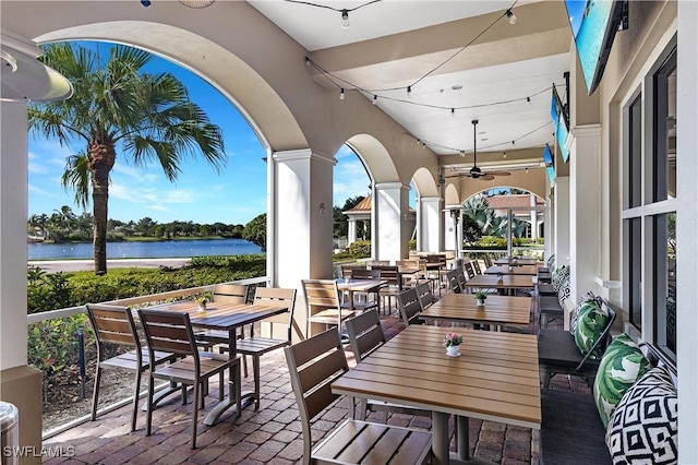 view of patio featuring ceiling fan and a water view