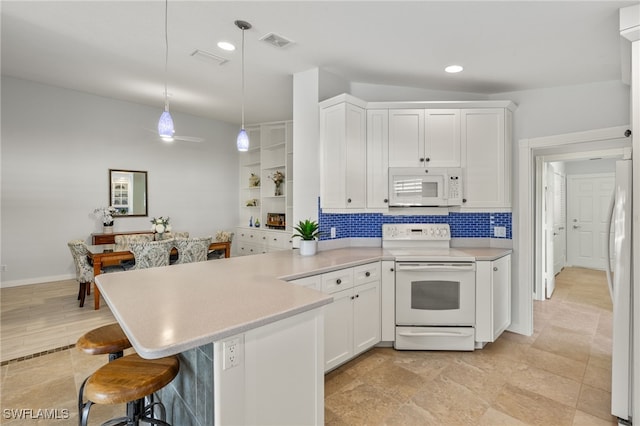 kitchen with pendant lighting, kitchen peninsula, a kitchen bar, white appliances, and white cabinetry