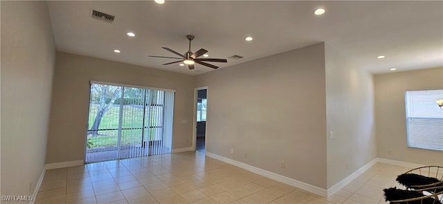 unfurnished room with a wealth of natural light, light tile patterned flooring, and ceiling fan