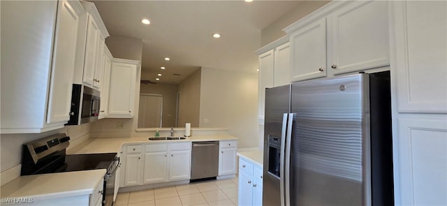 kitchen featuring light tile patterned floors, stainless steel appliances, sink, and white cabinets