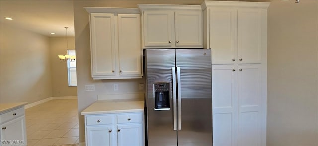 kitchen featuring white cabinetry, light tile patterned floors, decorative light fixtures, and stainless steel refrigerator with ice dispenser