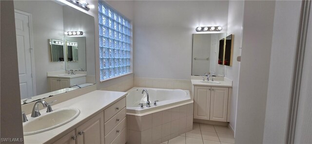 bathroom featuring vanity, a relaxing tiled tub, and tile patterned floors