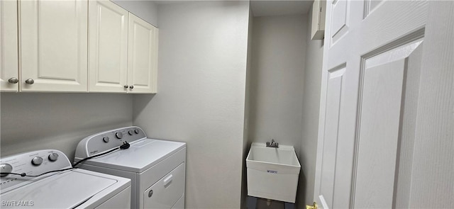 laundry room with cabinets, sink, and washing machine and dryer