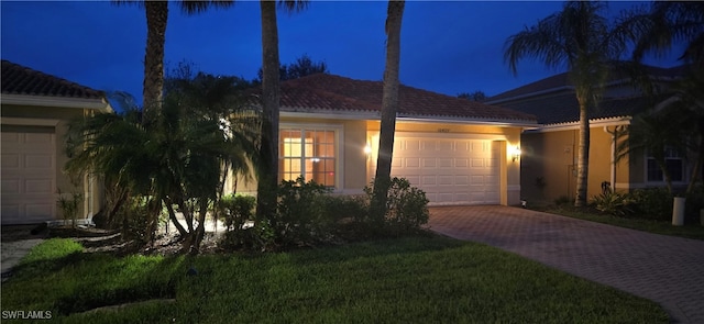 view of front of house featuring a garage and a lawn