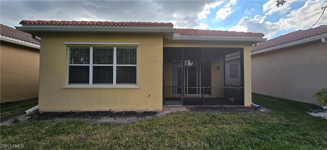 back of house with a yard and a sunroom