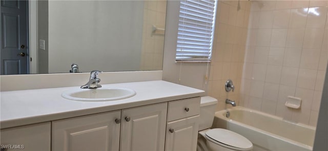 full bathroom featuring tiled shower / bath, vanity, and toilet