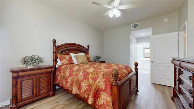 bedroom with light wood-type flooring, ensuite bath, and ceiling fan