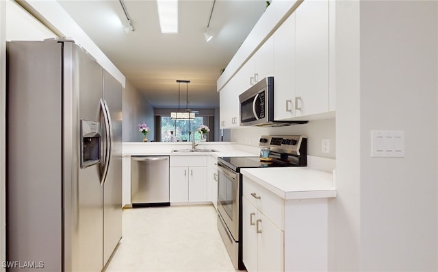 kitchen with white cabinetry, appliances with stainless steel finishes, hanging light fixtures, sink, and rail lighting