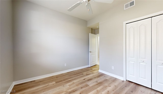 unfurnished bedroom featuring light hardwood / wood-style floors, ceiling fan, and a closet