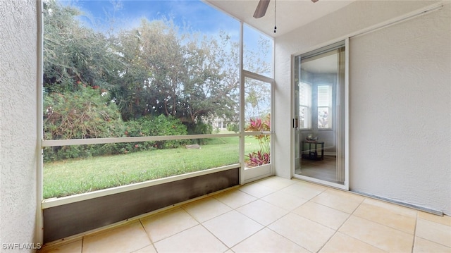 unfurnished sunroom featuring ceiling fan