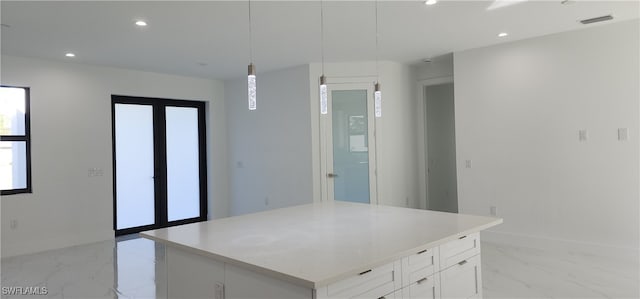 kitchen featuring white cabinets, pendant lighting, a center island, and french doors