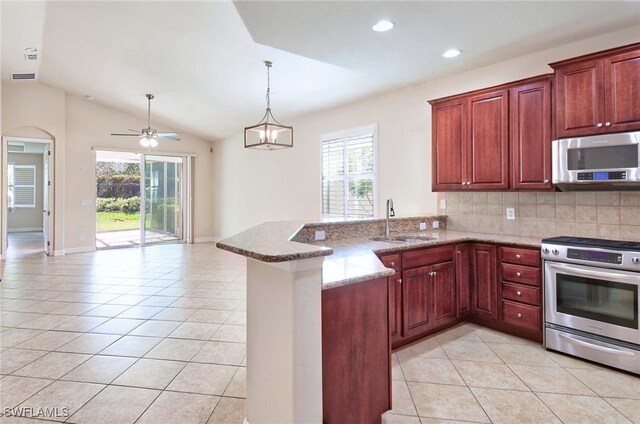 kitchen with plenty of natural light, kitchen peninsula, vaulted ceiling, and stainless steel appliances