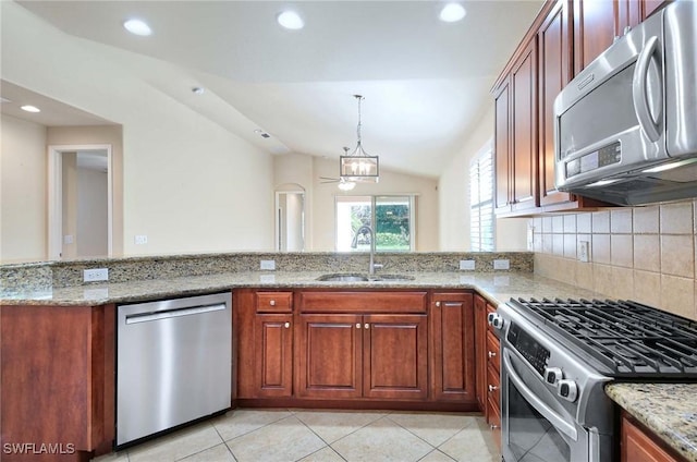 kitchen featuring light stone counters, stainless steel appliances, kitchen peninsula, and sink