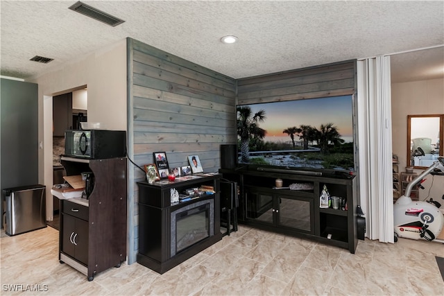 kitchen featuring wood walls and a textured ceiling