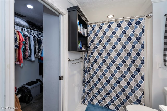 bathroom with toilet, a textured ceiling, and a shower with shower curtain