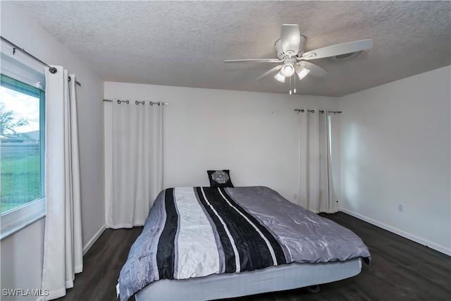 bedroom with a textured ceiling, dark hardwood / wood-style flooring, and ceiling fan