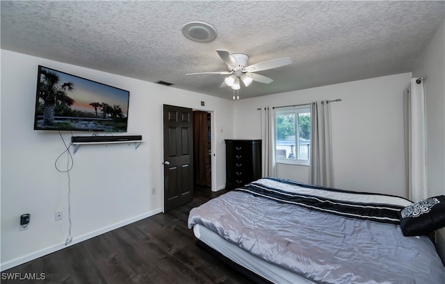 bedroom featuring a textured ceiling, dark wood-type flooring, and ceiling fan